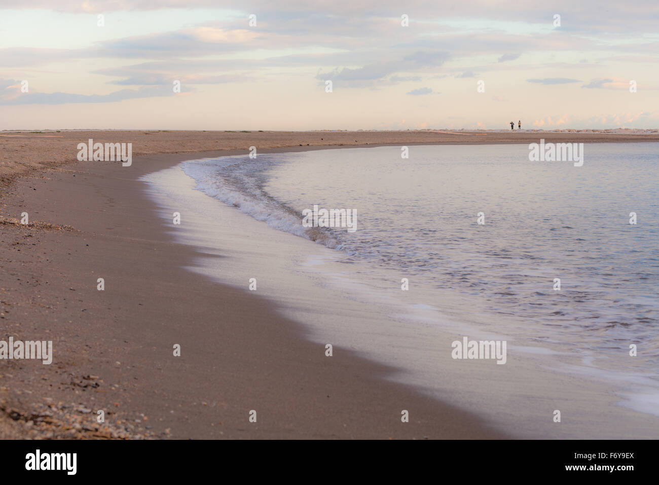 Aus dem Ozean Wellen, weichen Sandstrand feucht glitzern im Licht morgens zu verlassen. in der Nähe von Malaga Spanien Stockfoto