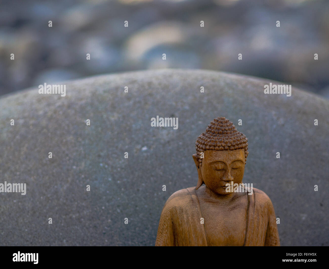 Buddha Meditaiting vor grauen Stein boulder Stockfoto