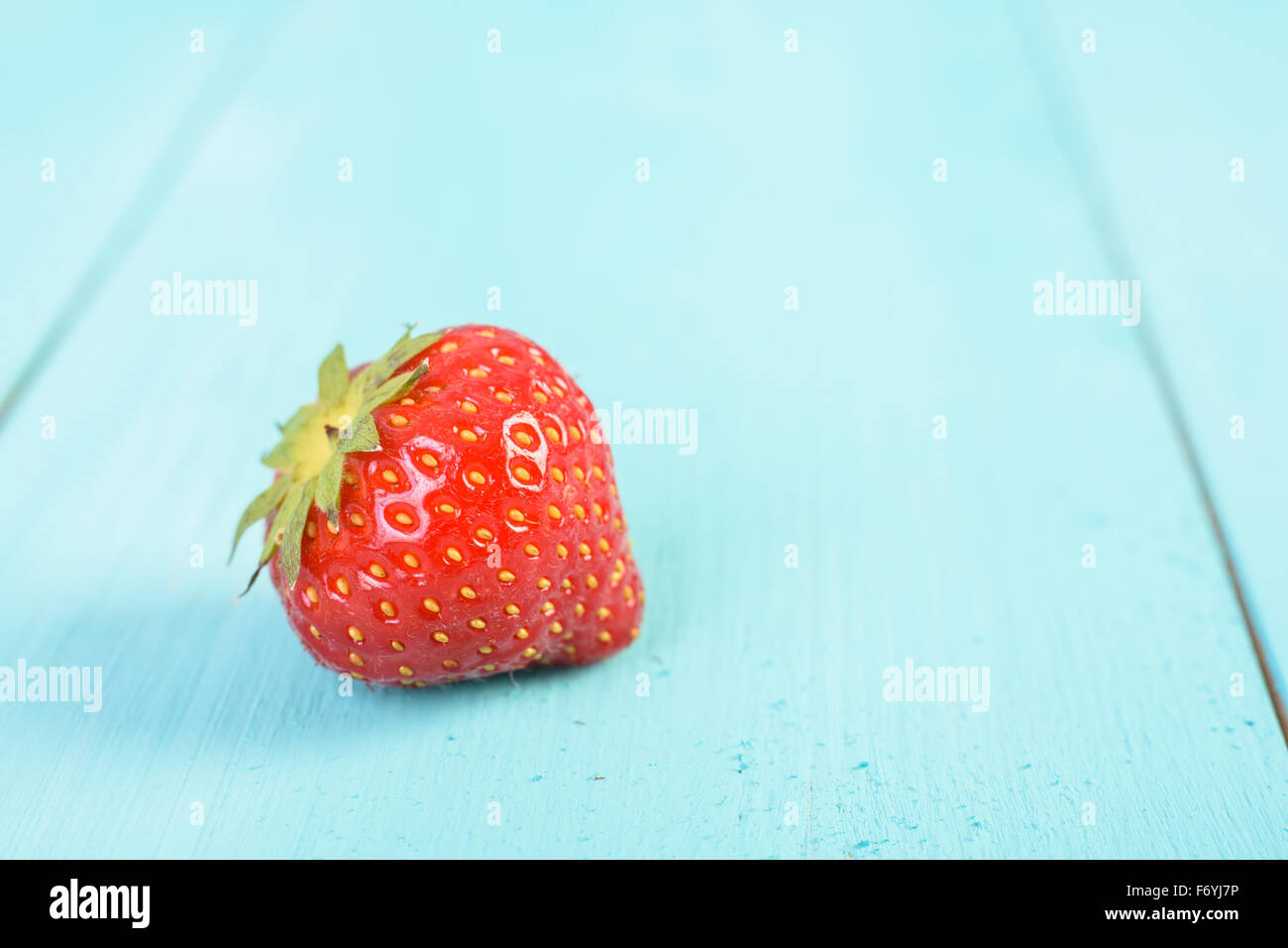 Frische rote Erdbeere auf blaue Holz Bretter Hintergrund Stockfoto