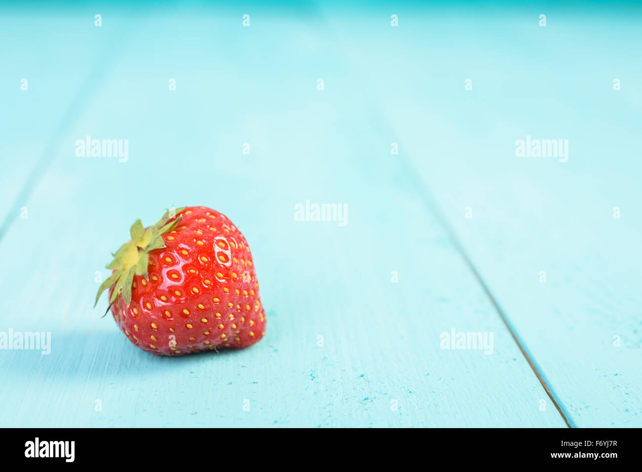 Frische rote Erdbeere auf blaue Holz Bretter Hintergrund Stockfoto