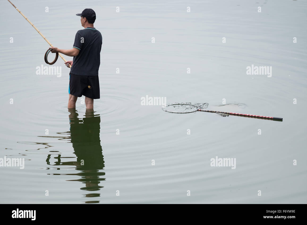 Ein Mann Angeln in Hanoi, Vietnam - West Lake Stockfoto