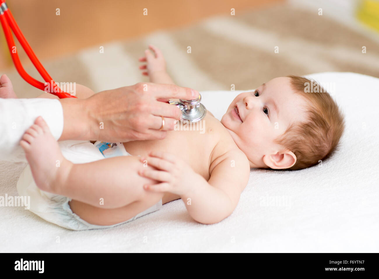 Kinderarzt untersucht drei Monate Baby Boy. Arzt mit einem Stethoskop Kid es Truhe überprüft Herzschlag hören. Stockfoto