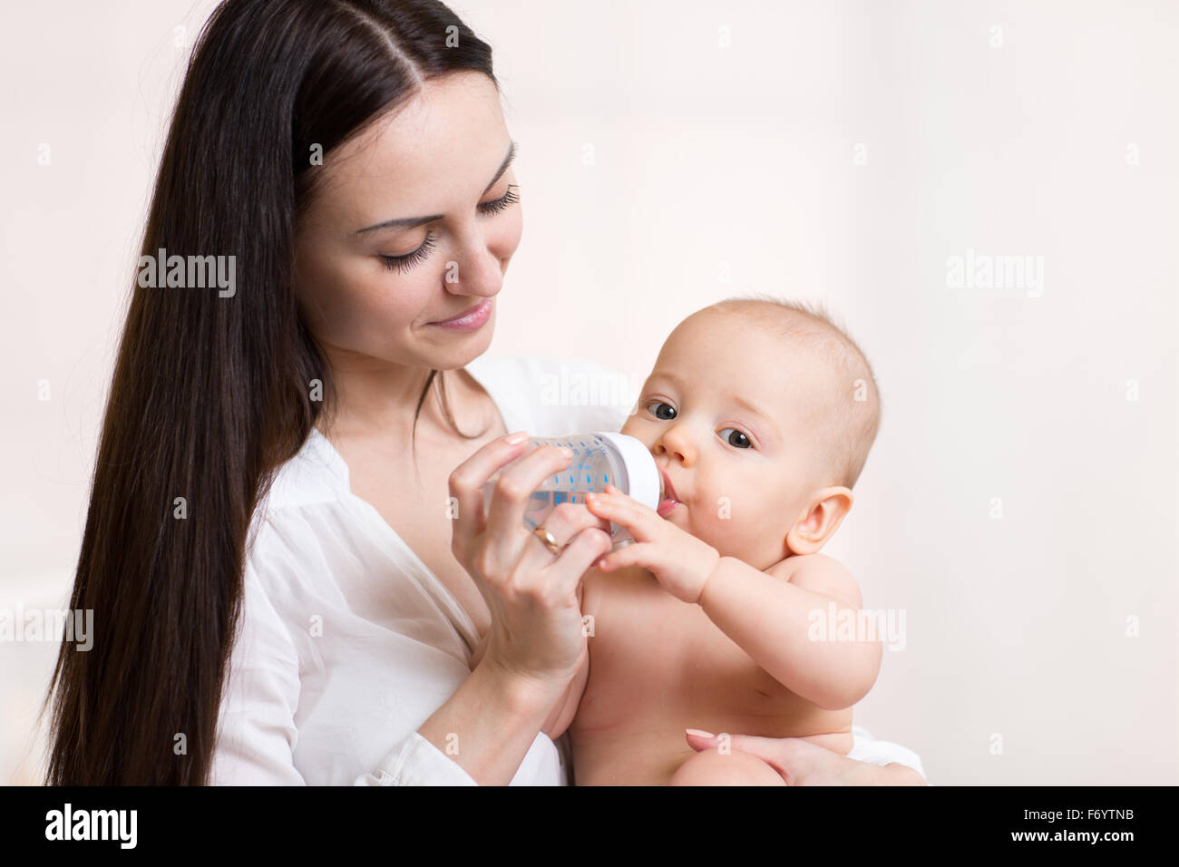 glückliche Mutter füttert ihr Baby-Flasche Stockfoto