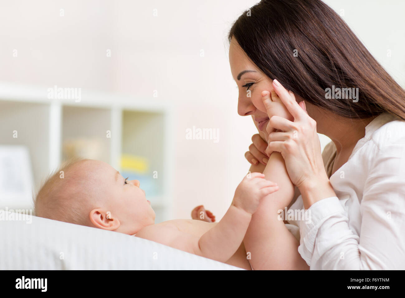 Mutter schaut mit Liebe Baby. Elternschaft Glück Konzept Stockfoto
