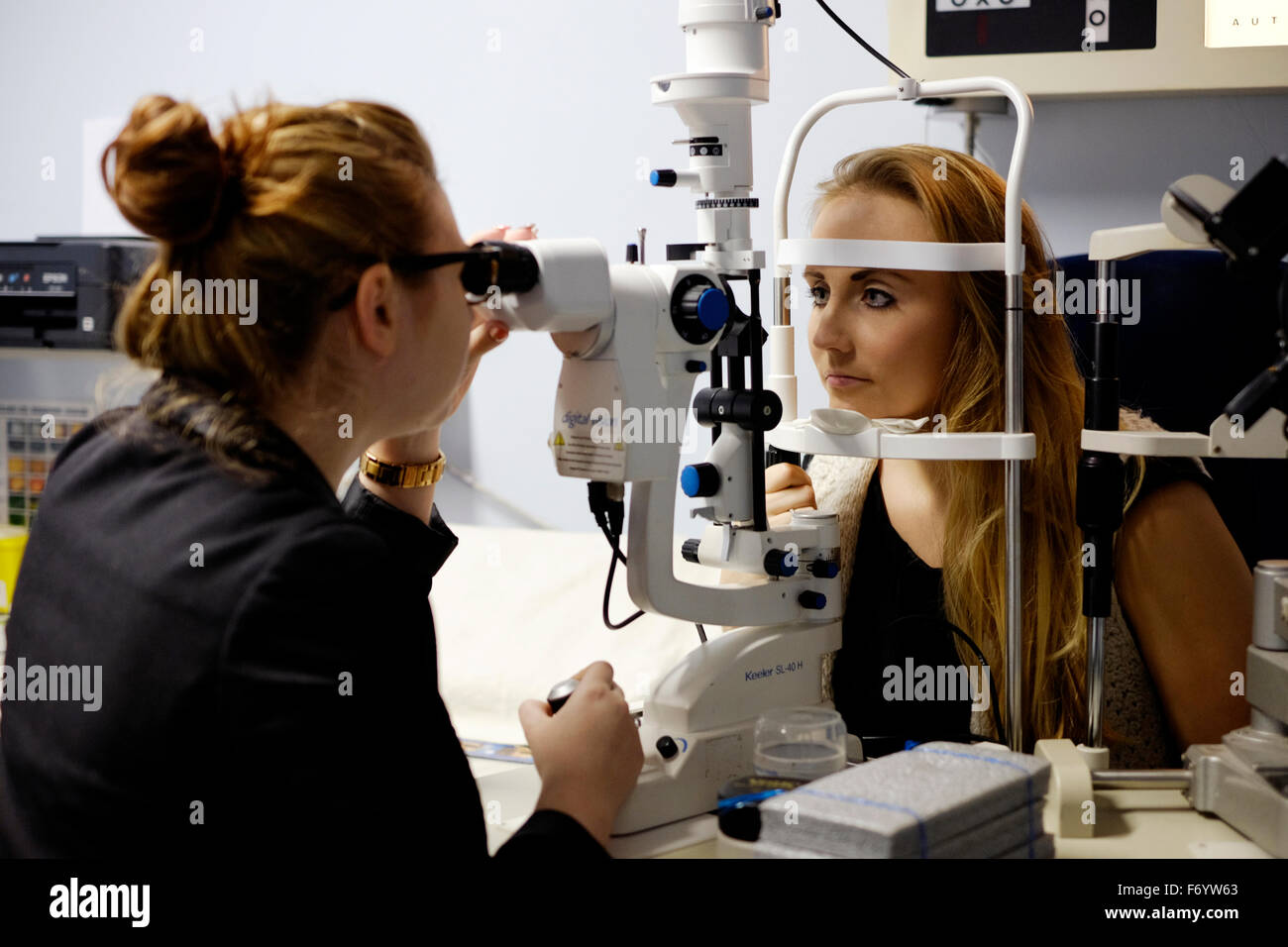 junge Frau empfangen Augenpflege bei einem Optiker-Shop in England uk Stockfoto