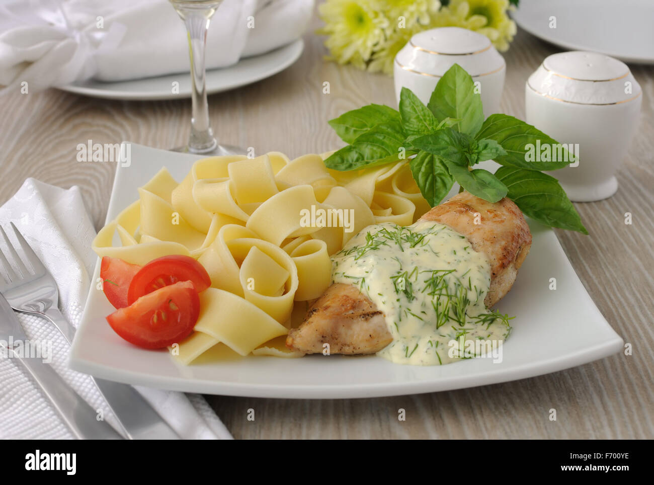 Italienische Pasta - Pappardelle mit Huhn in Sahne-Sauce und Kirschtomaten Stockfoto