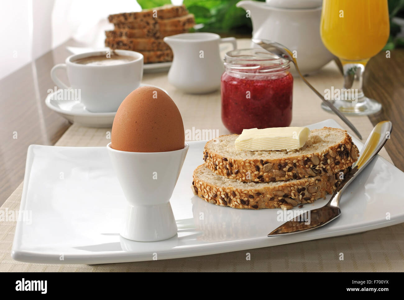 Wachsweiches Ei mit Haferflocken Brot mit Butter zum Frühstück Stockfoto