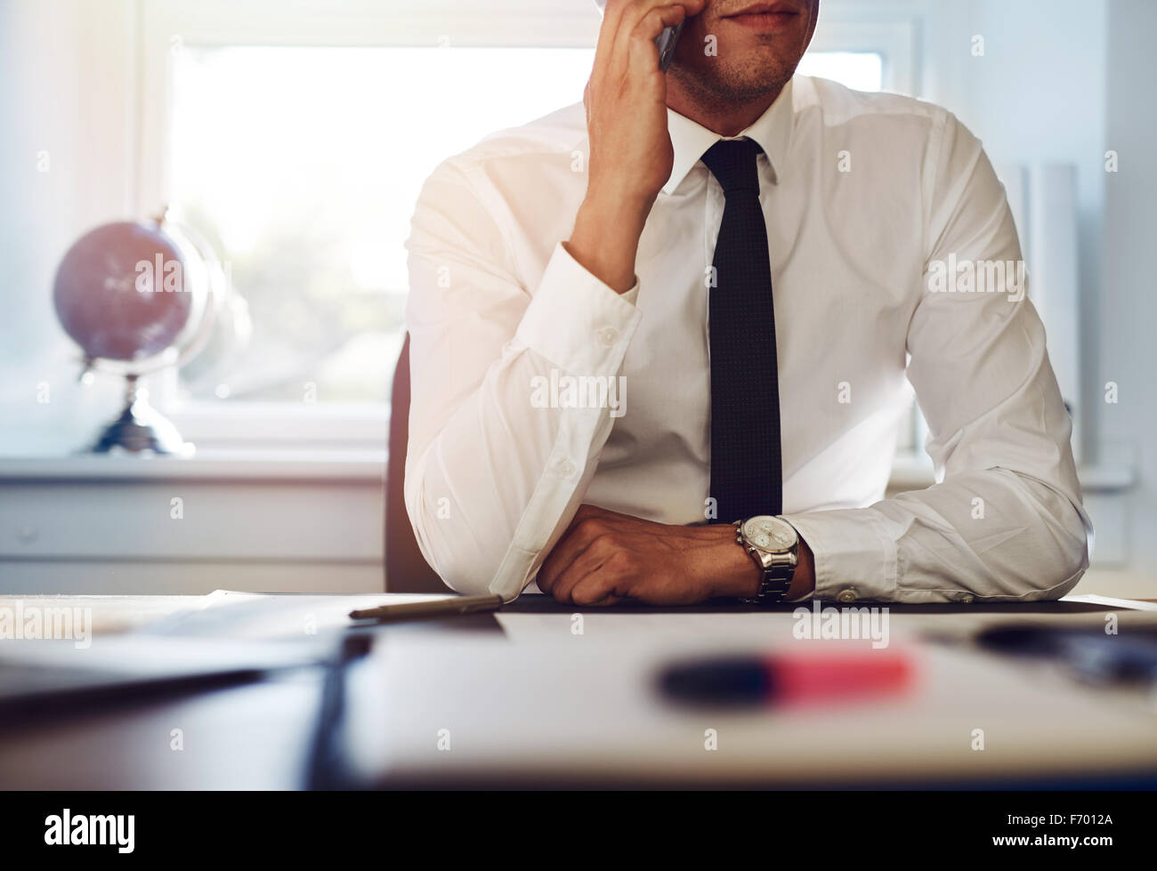 Nahaufnahme eines Business-Mann sitzt an seinem Schreibtisch am Telefon sprechen Stockfoto