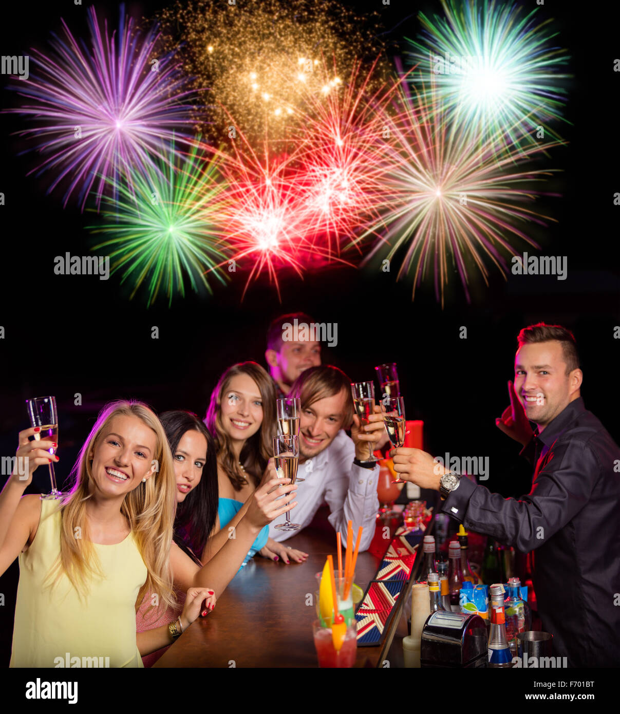 Glückliche junge Menschen Klirren mit Champagner und Feuerwerk Stockfoto