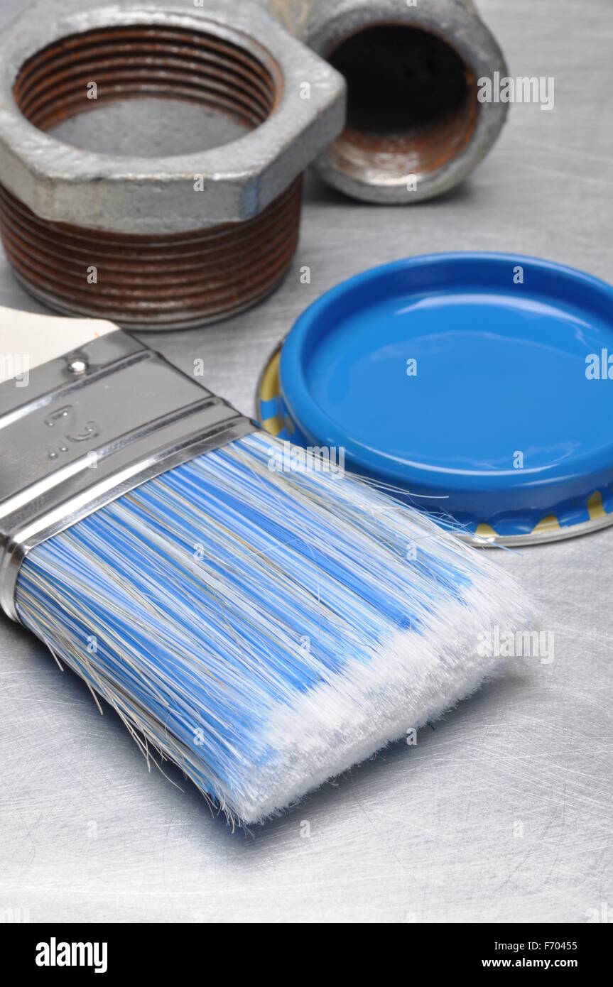 Blauer Farbe Deckel mit Pinsel und Metall Sanitär-Teile auf grauem Hintergrund Metall Stockfoto