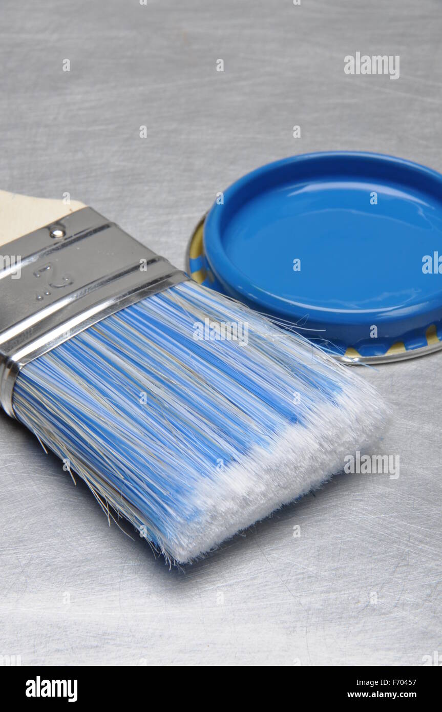 Blauer Farbe Deckel mit Pinsel und Metall Sanitär-Teile auf grauem Hintergrund Metall Stockfoto