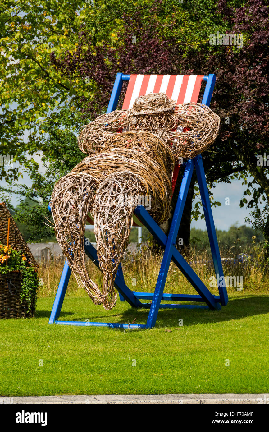 Mann auf einem Liegestuhl, eine Weide Skulptur made by Cherry Chung, für "Bury in voller Blüte", Bury, Greater Manchester, England, UK Stockfoto