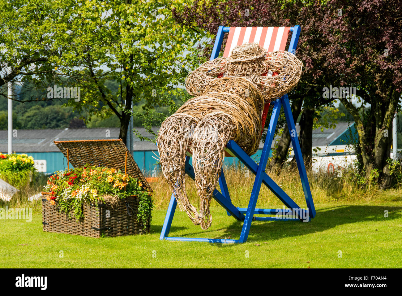 Mann auf einem Liegestuhl, eine Weide Skulptur made by Cherry Chung, für "Bury in voller Blüte", Bury, Greater Manchester, England, UK Stockfoto