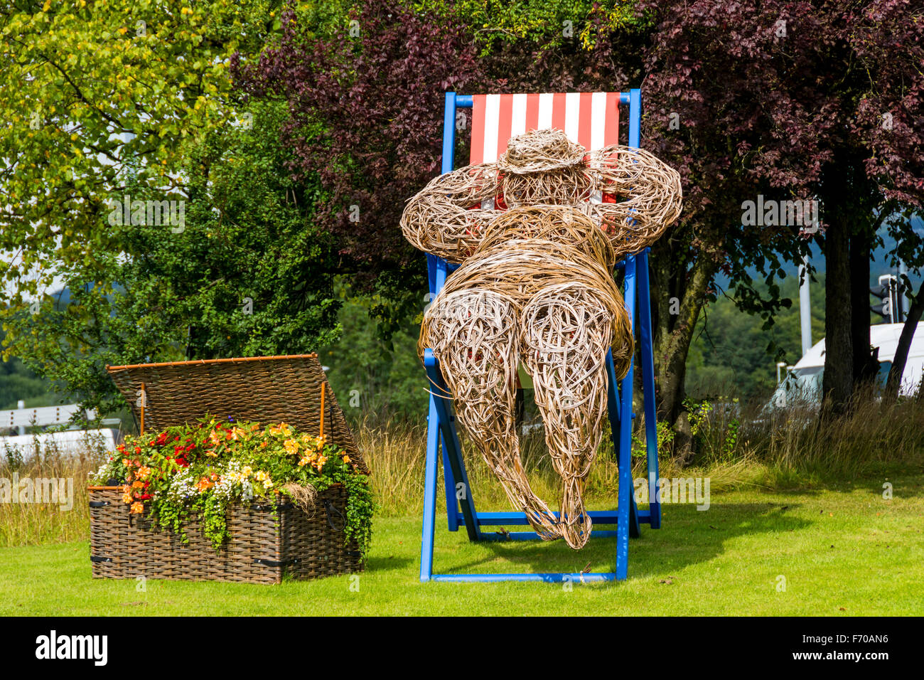 Mann auf einem Liegestuhl, eine Weide Skulptur made by Cherry Chung, für "Bury in voller Blüte", Bury, Greater Manchester, England, UK Stockfoto