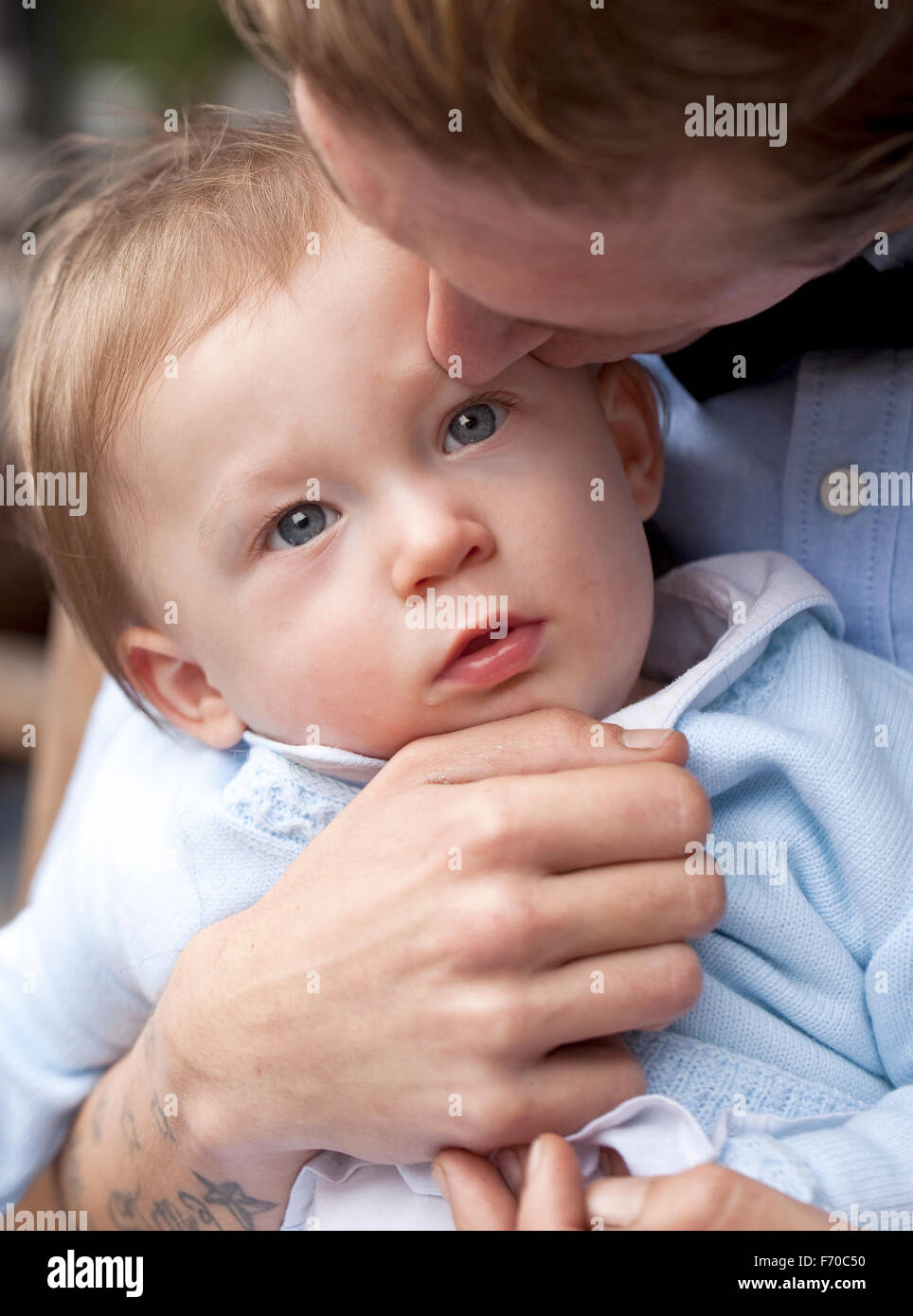 Sanften Kuss. Ein junges Baby-junge wird sanft von seinem Vater geküsst wird. Sein Vater hält das Kind zärtlich. Stockfoto
