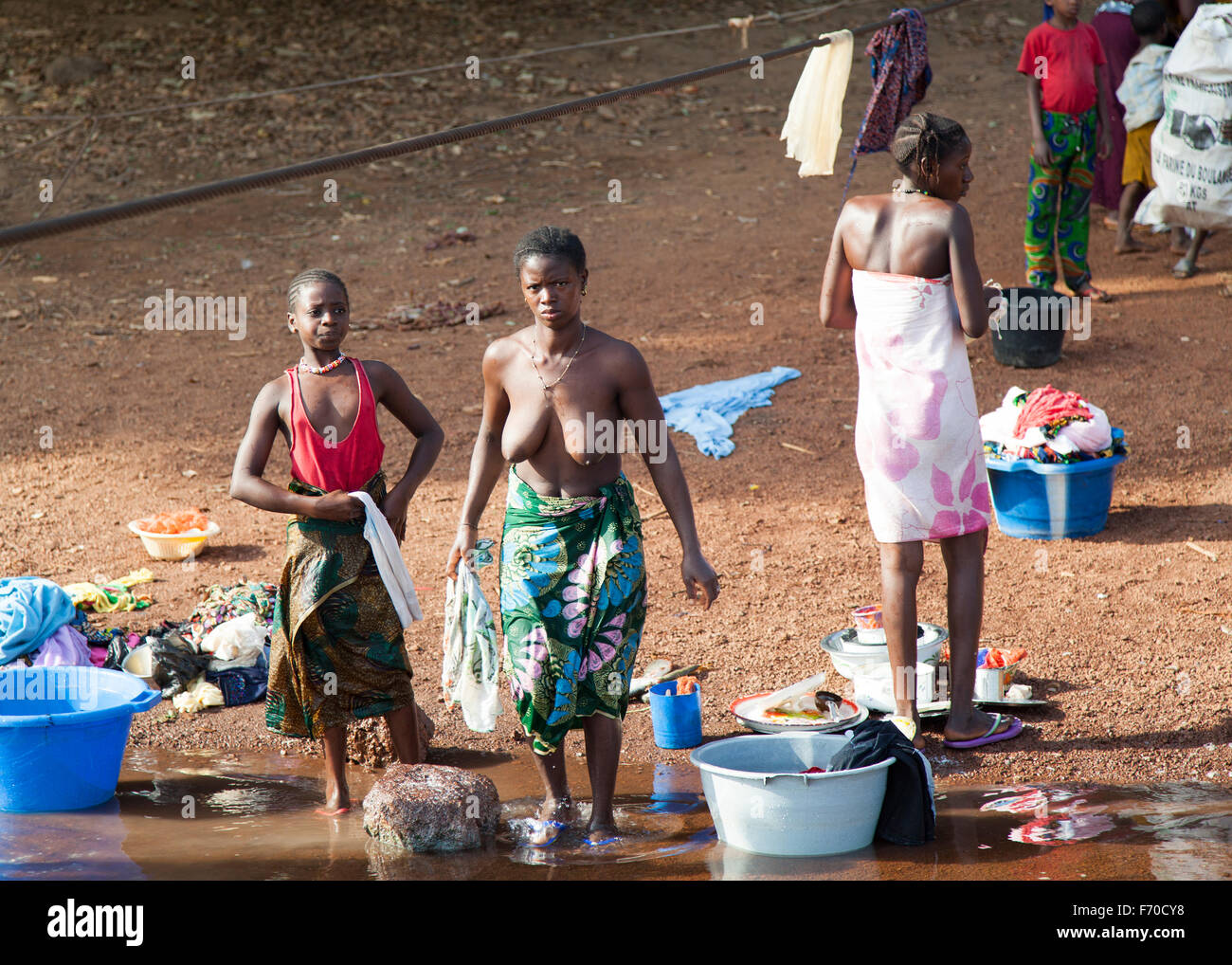 Gabu, Guinea-Bissau - 2. April 2014: afrikanische Frauen Bad nehmen und Wäsche am Fluss in ländlichen Guinea-Bissau Stockfoto