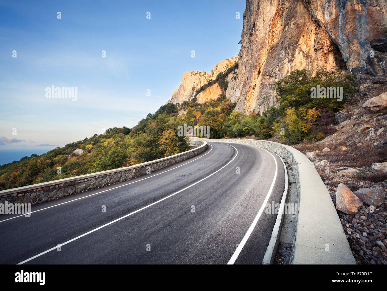 Asphaltierte Straße im herbstlichen Wald bei Sonnenaufgang. Krimberge. Stockfoto