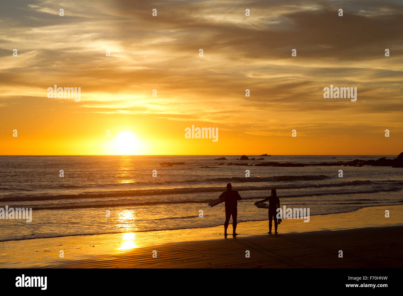 Zwei Surfer am Ufer Sonnenuntergang Stockfoto