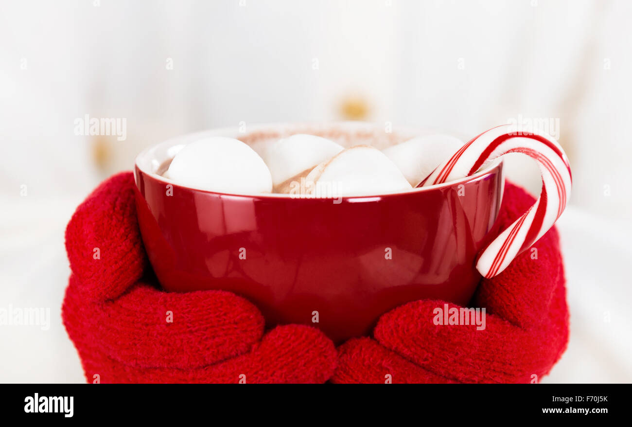 Rote Tasse heiße Schokolade mit Marshmallows und eine Zuckerstange Stockfoto
