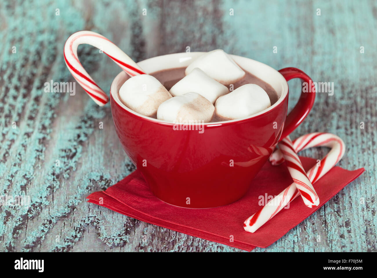 Heiße Schokolade mit Marshmallows und Zuckerstangen in eine rote Tasse Stockfoto