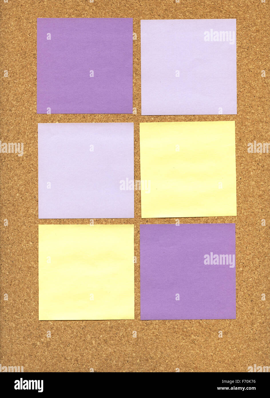 Violetten und gelben Haftnotizen auf einer Pinnwand Stockfoto