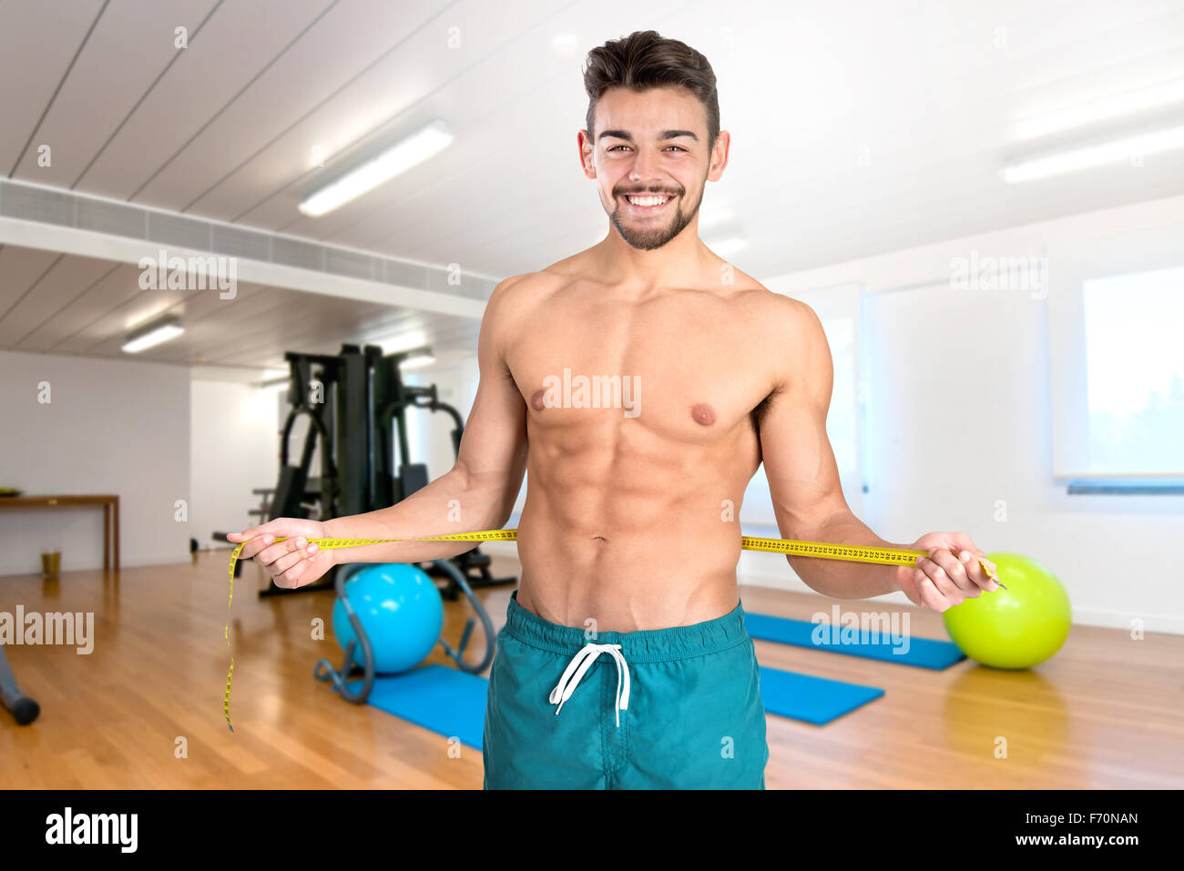 Muskulös und Fit junger Mann mit großen Bauchmuskeln und Maßband in der Turnhalle Stockfoto