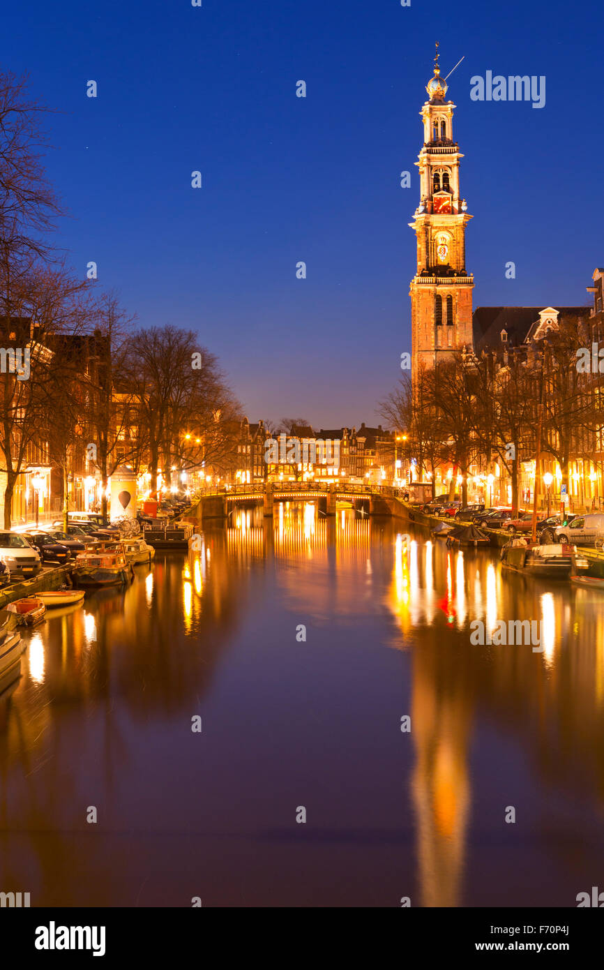 Die Westerkerk (Westkirche) entlang des Kanals der Prinsengracht in Amsterdam bei Nacht. Stockfoto