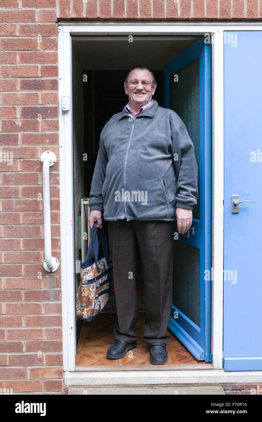 Älterer Mann vor seiner Haustür stehen etwa, einkaufen gehen, Stockfoto