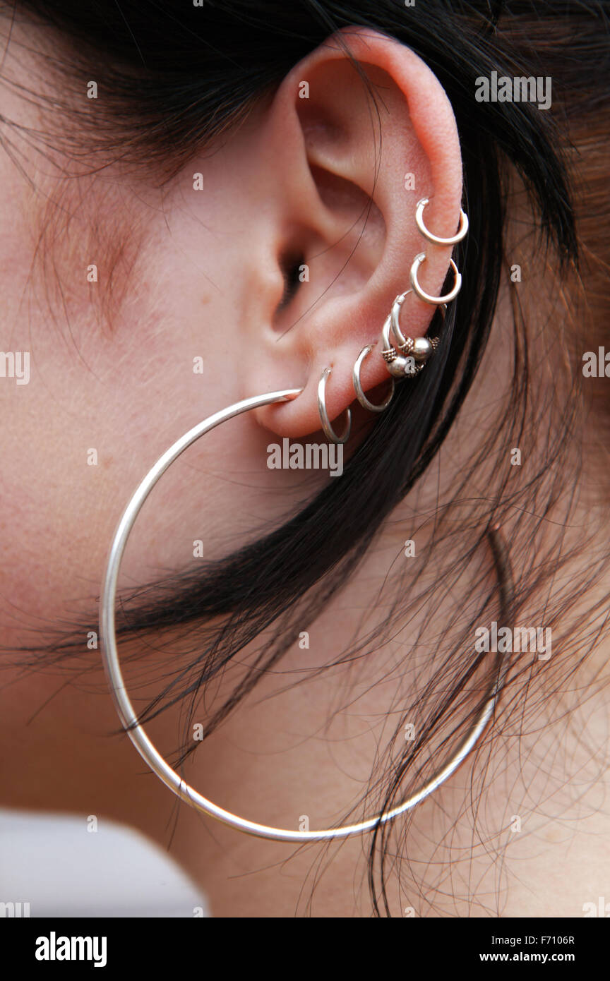 Seitenansicht einer jungen Frau mit mehreren Ohrenpiercing, Stockfoto