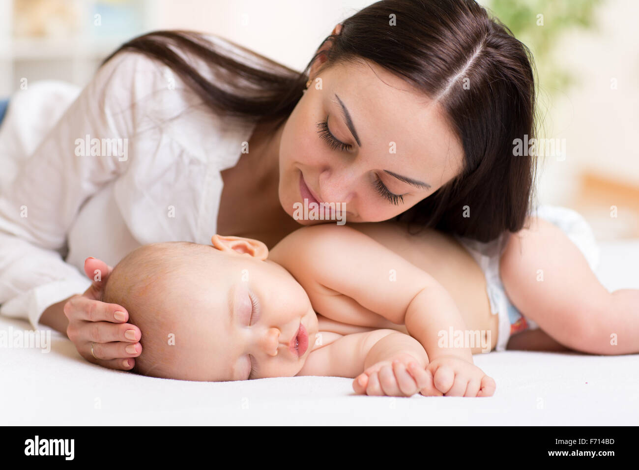 glückliche junge Mutter in der Nähe von schlafenden baby Stockfoto