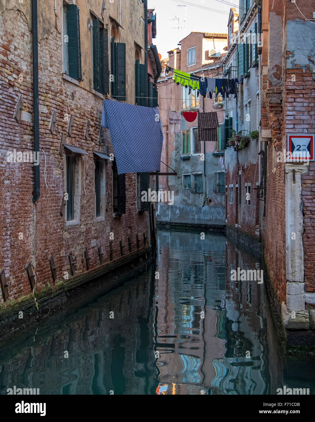 Venedig-Castello. Verwittert, Wasser beschädigt venezianische Häusern mit Wäsche hängen zwischen den Häusern über einen Kanal Stockfoto