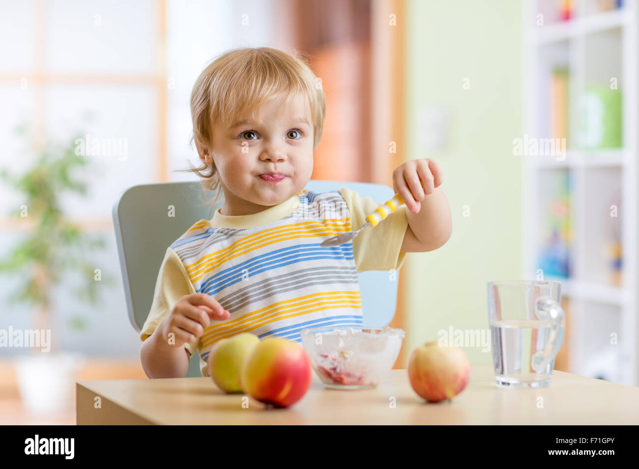 Kind gesund Essen mit dem Löffel zu Hause Stockfoto