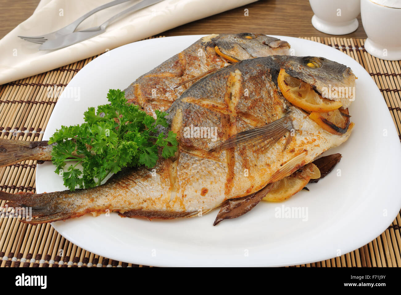 Dorado gebackene Fisch mit Zitrone auf eine Platte-Nahaufnahme Stockfoto
