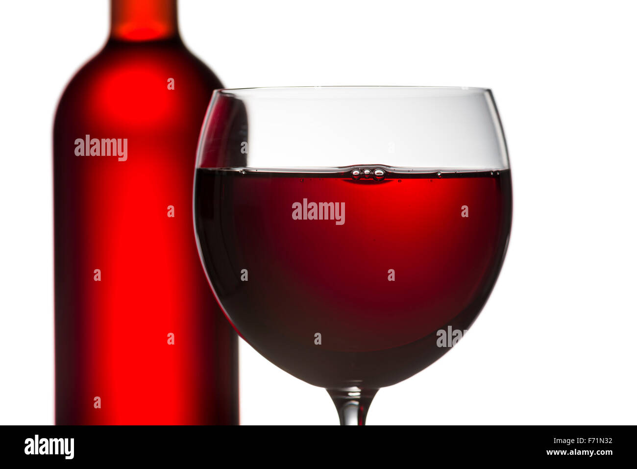 Nahaufnahme von Glas Rotwein mit volle Flasche auf weißem Hintergrund Stockfoto