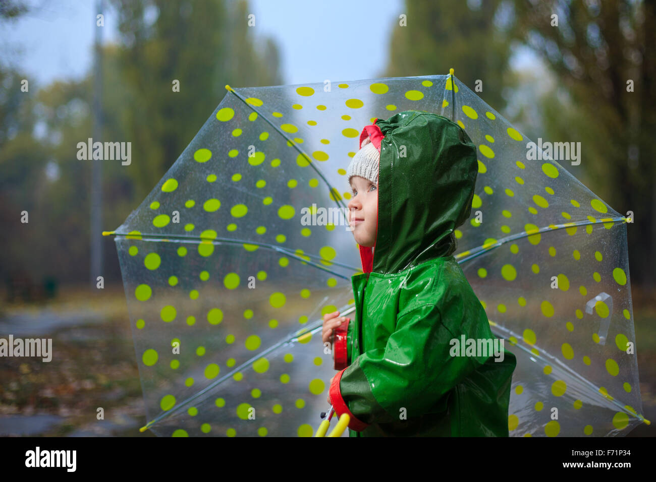 Kleinkind und Regenschirm im Herbst regnerischen park Stockfoto