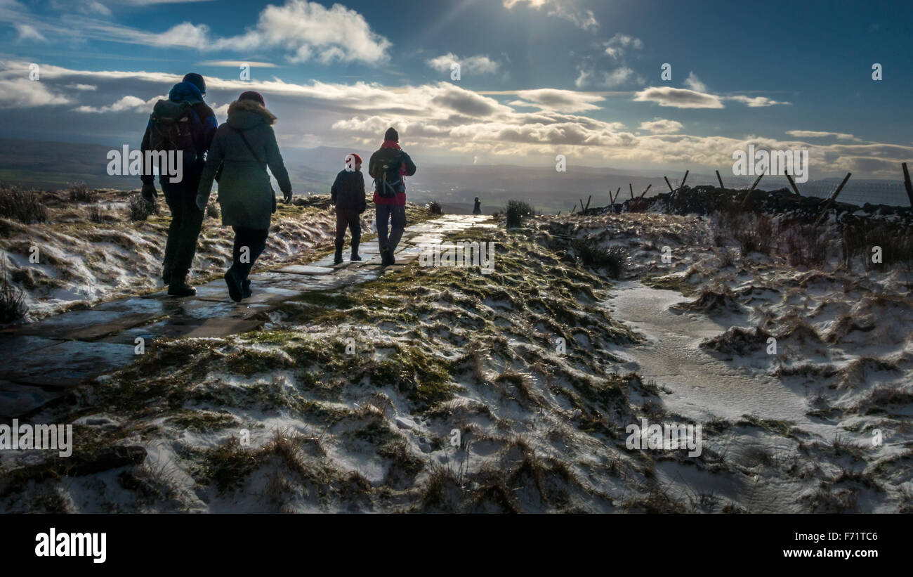 Menschen gehen aus einem verschneiten Berg Pen-y-Gent; eines der berühmten Yorkshire drei Zinnen Berge in die Landschaft der Yorkshire Dales. Stockfoto