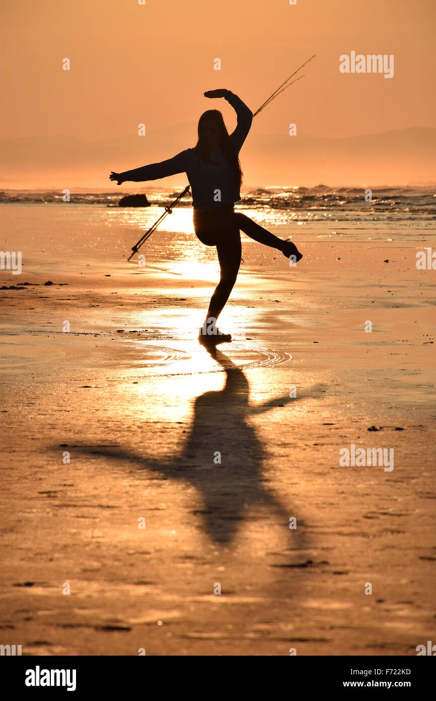 Tanzen am Strand bei Sonnenuntergang Stockfoto
