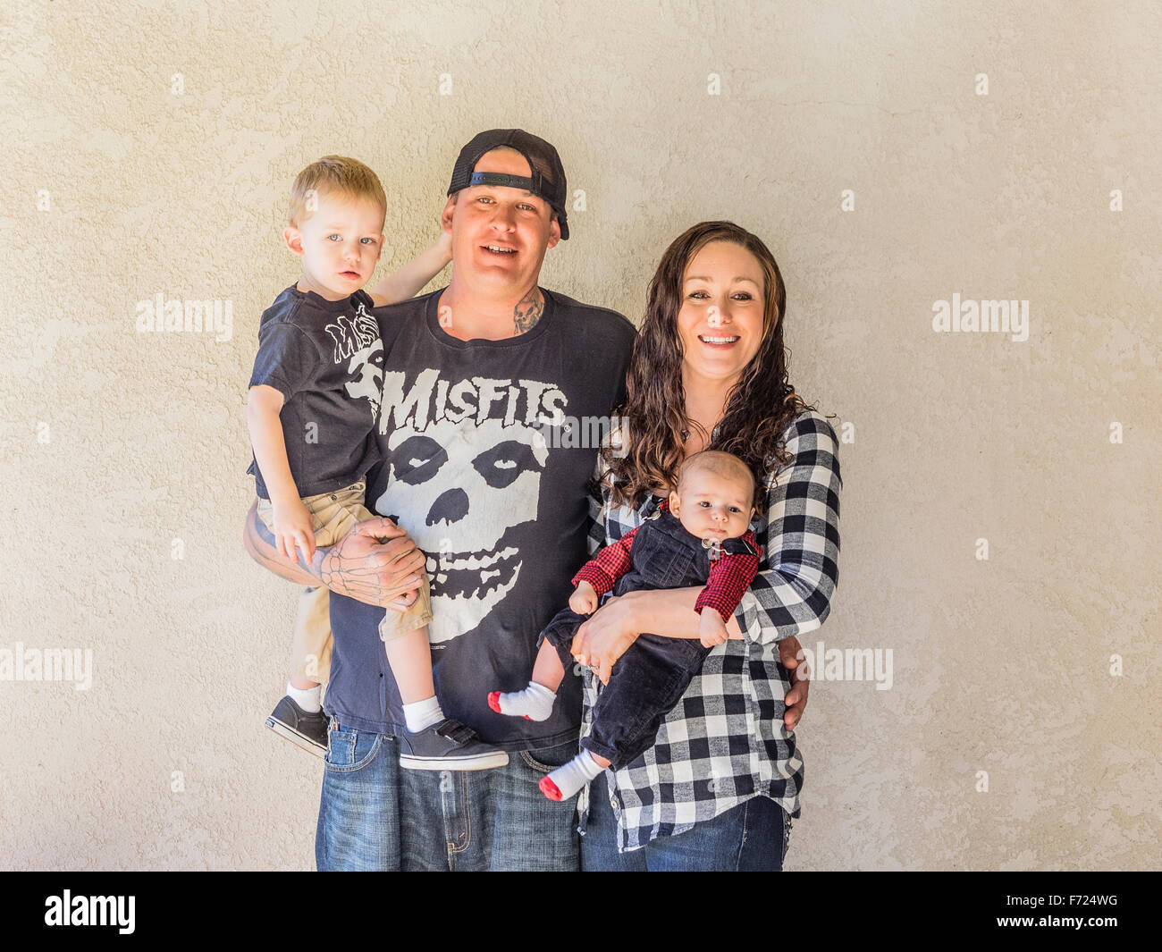 Portrait einer Millenniumsgeneration Familie mit zwei Kindern und tätowierte Vater zusammenstehen in Chico, Kalifornien. Stockfoto