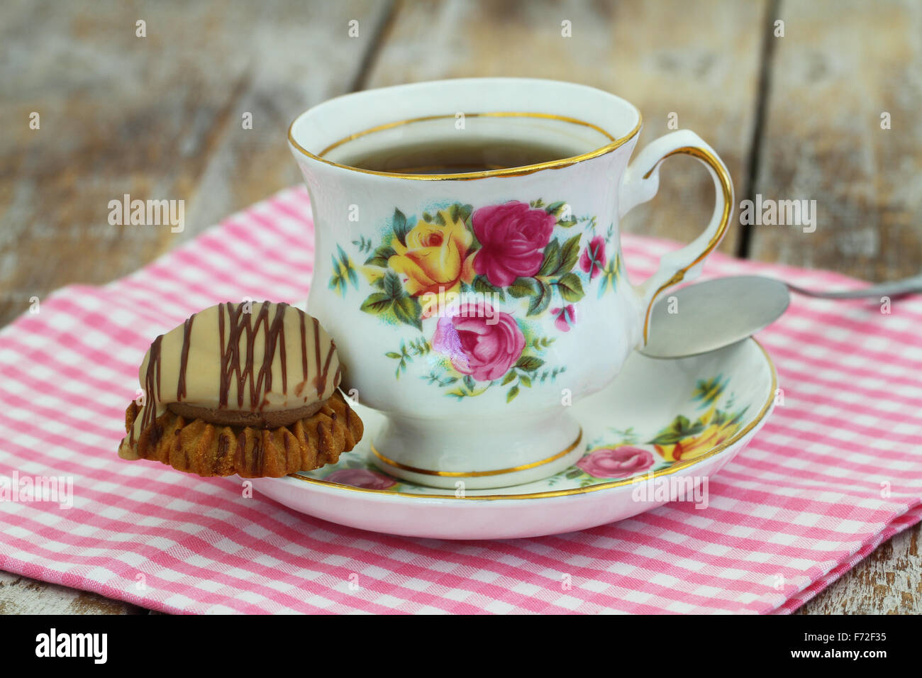 Tee in bunte Vintage Porzellantasse mit Schokolade und Toffee knusprige Keks Stockfoto