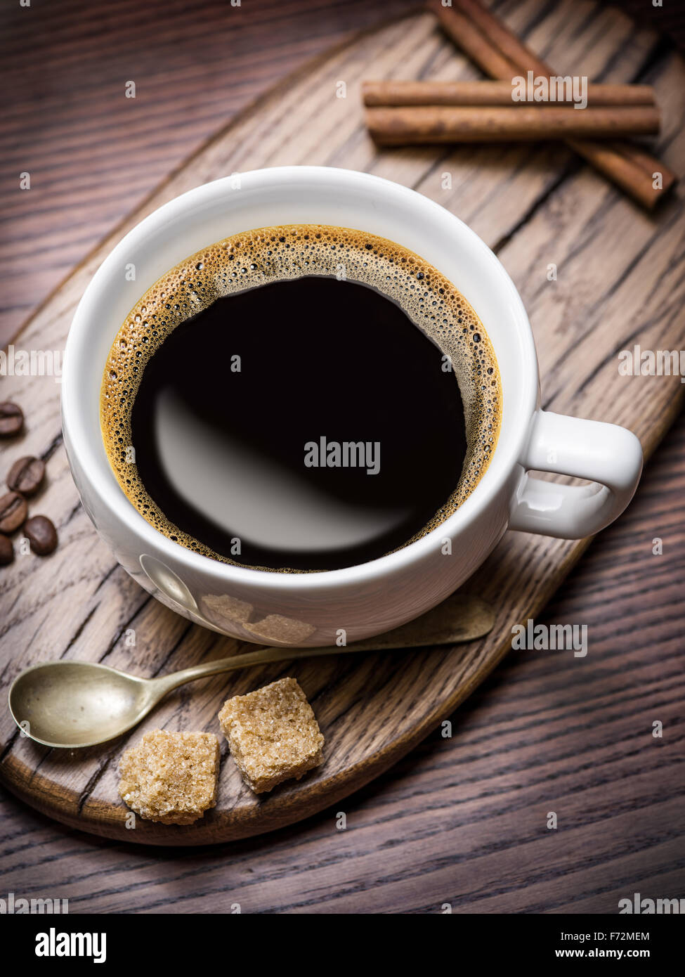 Tasse Kaffee und Rohrzucker Würfel auf Holztisch. Stockfoto