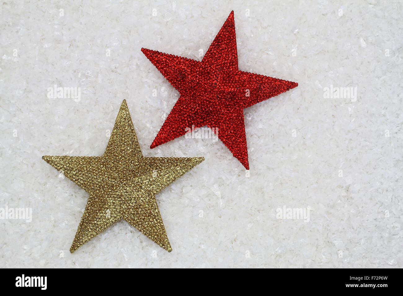 Rote und goldene Sterne bedeckt mit Glitzer auf verschneiten Oberfläche mit Textfreiraum Stockfoto