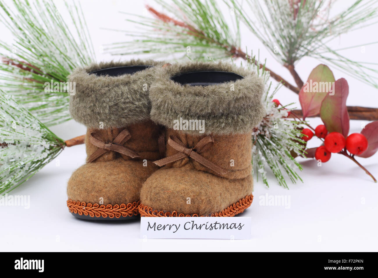 Merry Christmas Card with Mini fühlte sich Schuhe und Pinien bedeckten mit Schneeflocken Stockfoto