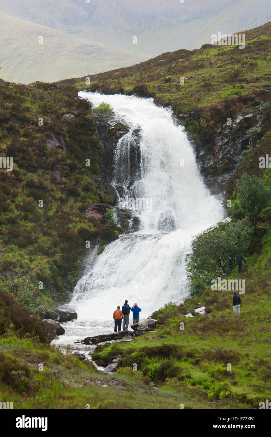 Wanderer auf der Suche an einem Wasserfall auf der Isle Of Skye - Schottisches Hochland. Stockfoto