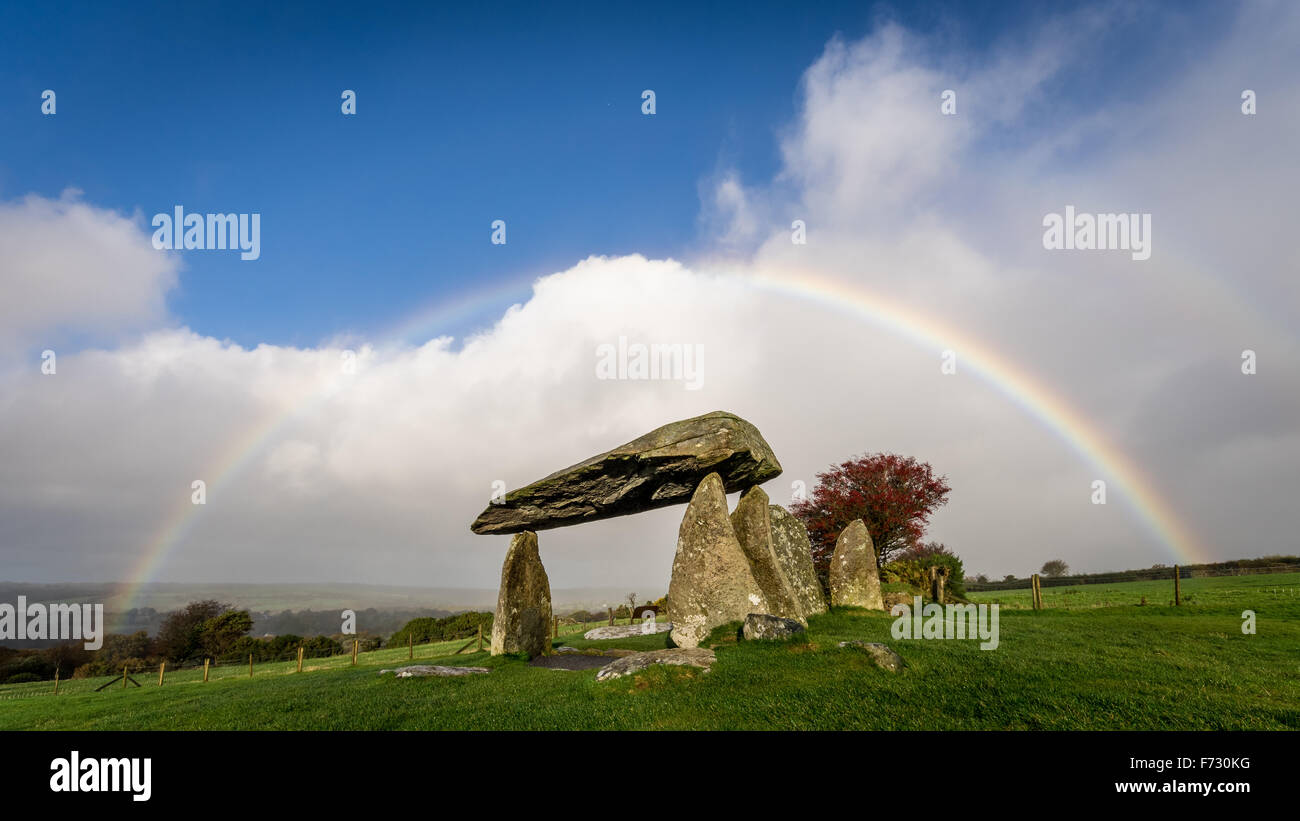 Pentre Ifan, den größten und am besten erhaltenen neolithischen Dolmen in Wales, unter einem Regenbogen, mit blauem Himmel und Wolken. Mystische geplante alten Denkmal. Stockfoto