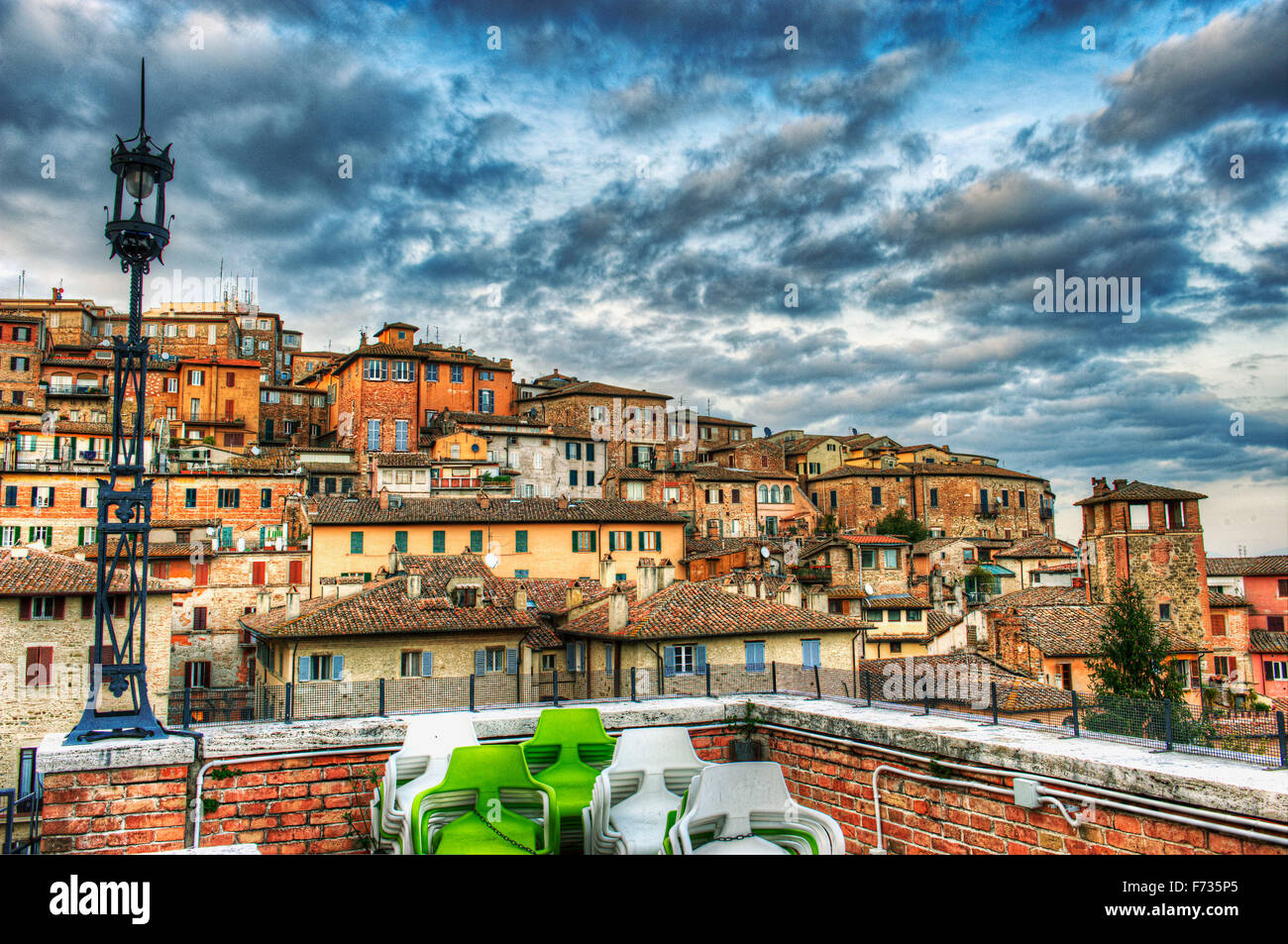 Perugia, Umbrien, Italien. Panorama der Altstadt der Stadt. Im Vordergrund eine alte Straßenlaterne von Anfang des Jahrhunderts Stockfoto