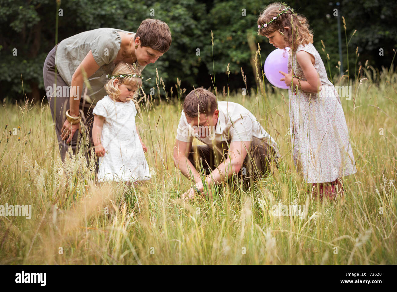 Familie mit zwei Kindern auf einer Wiese spielen. Stockfoto