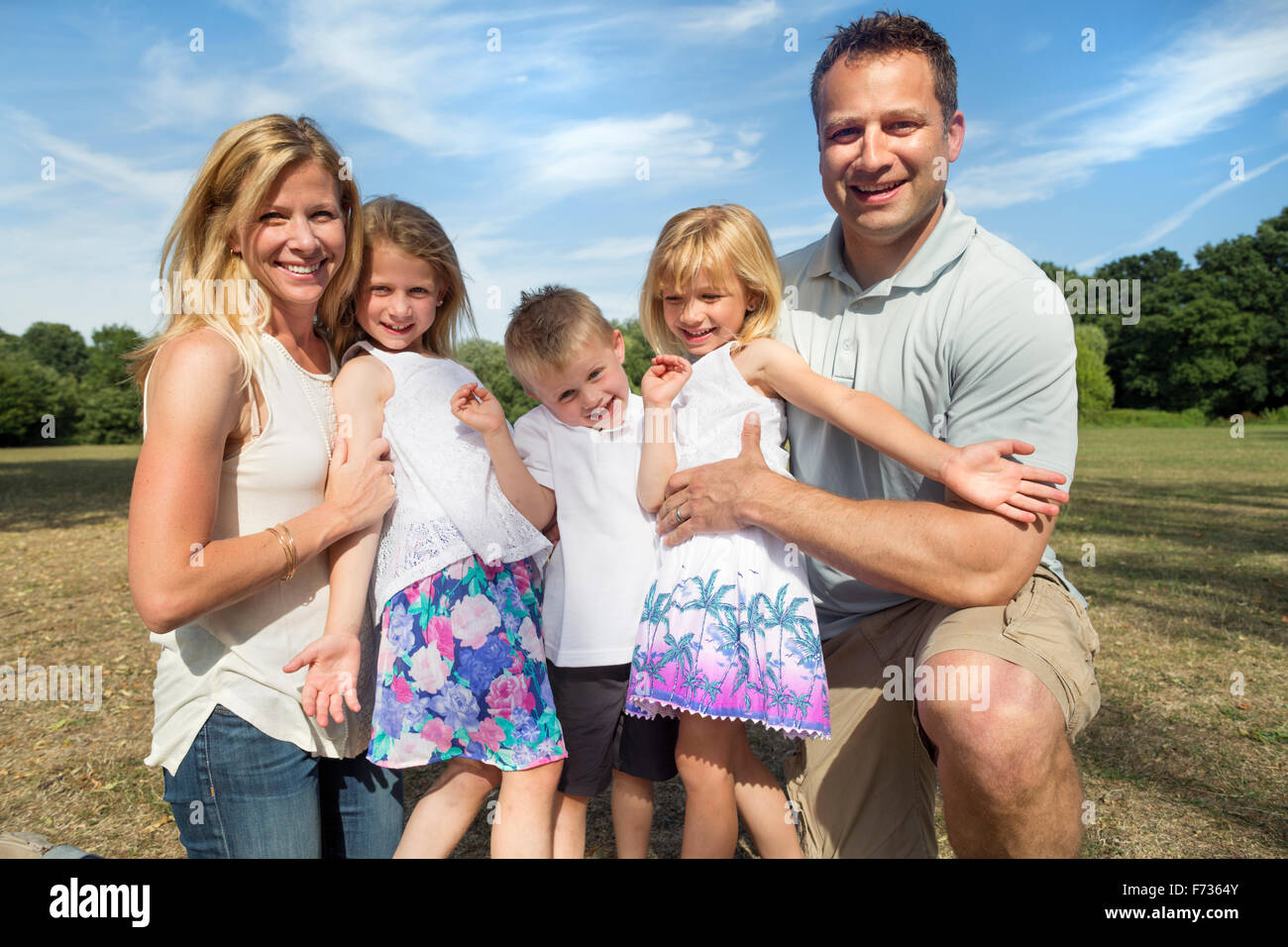 Familie mit drei Kindern in einem Park posiert für ein Foto. Stockfoto