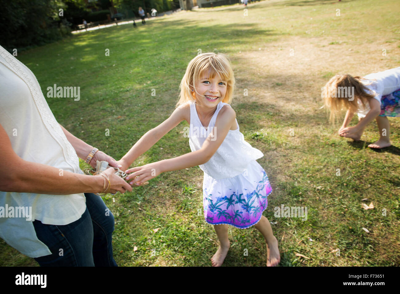Mutter mit ihren Töchtern in einem Park spielen. Stockfoto