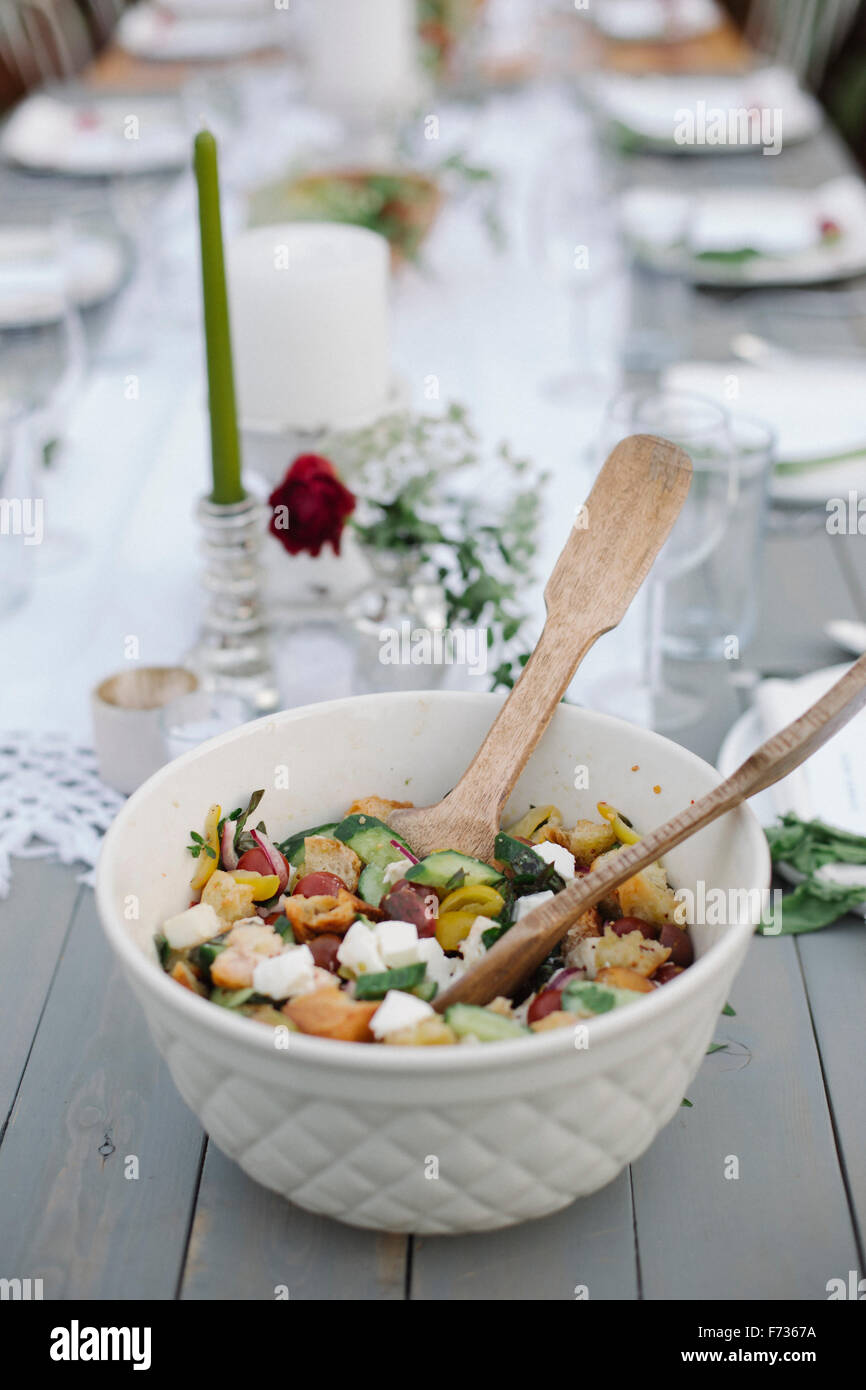 Eine Schüssel Salat auf einem Tisch in einem Garten. Stockfoto