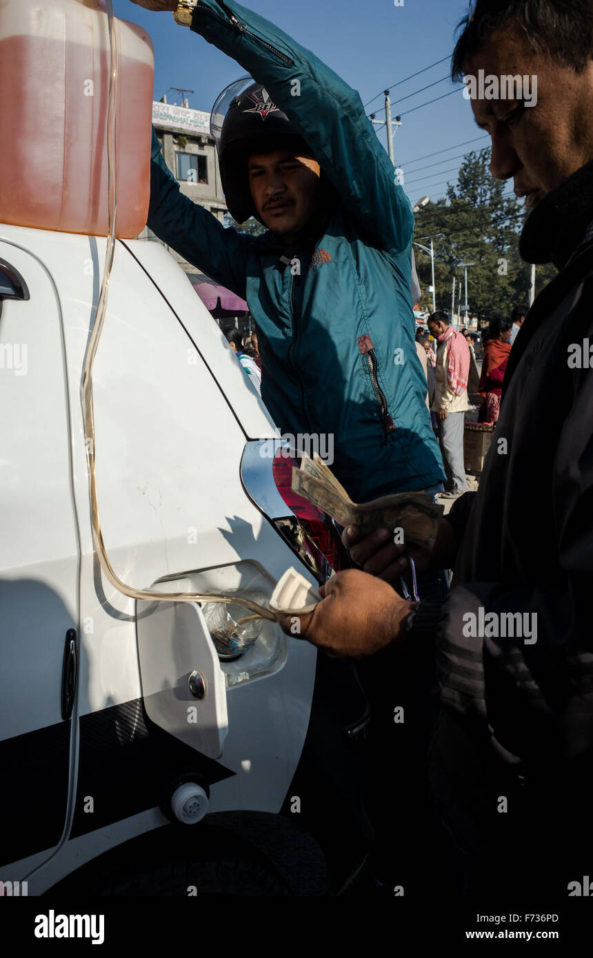 Kathmandu, Nepal, 24. November 2015 Menschen in ihrem Auto mit einer Gallone Benzin nachfüllen gekauft "Schwarzmarkt" Stockfoto